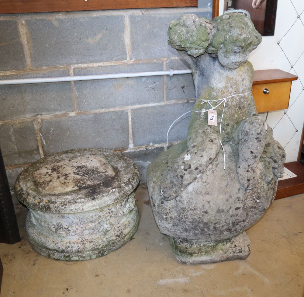 A reconstituted stone garden ornament of a bacchic putti on circular plinth, H.106cm